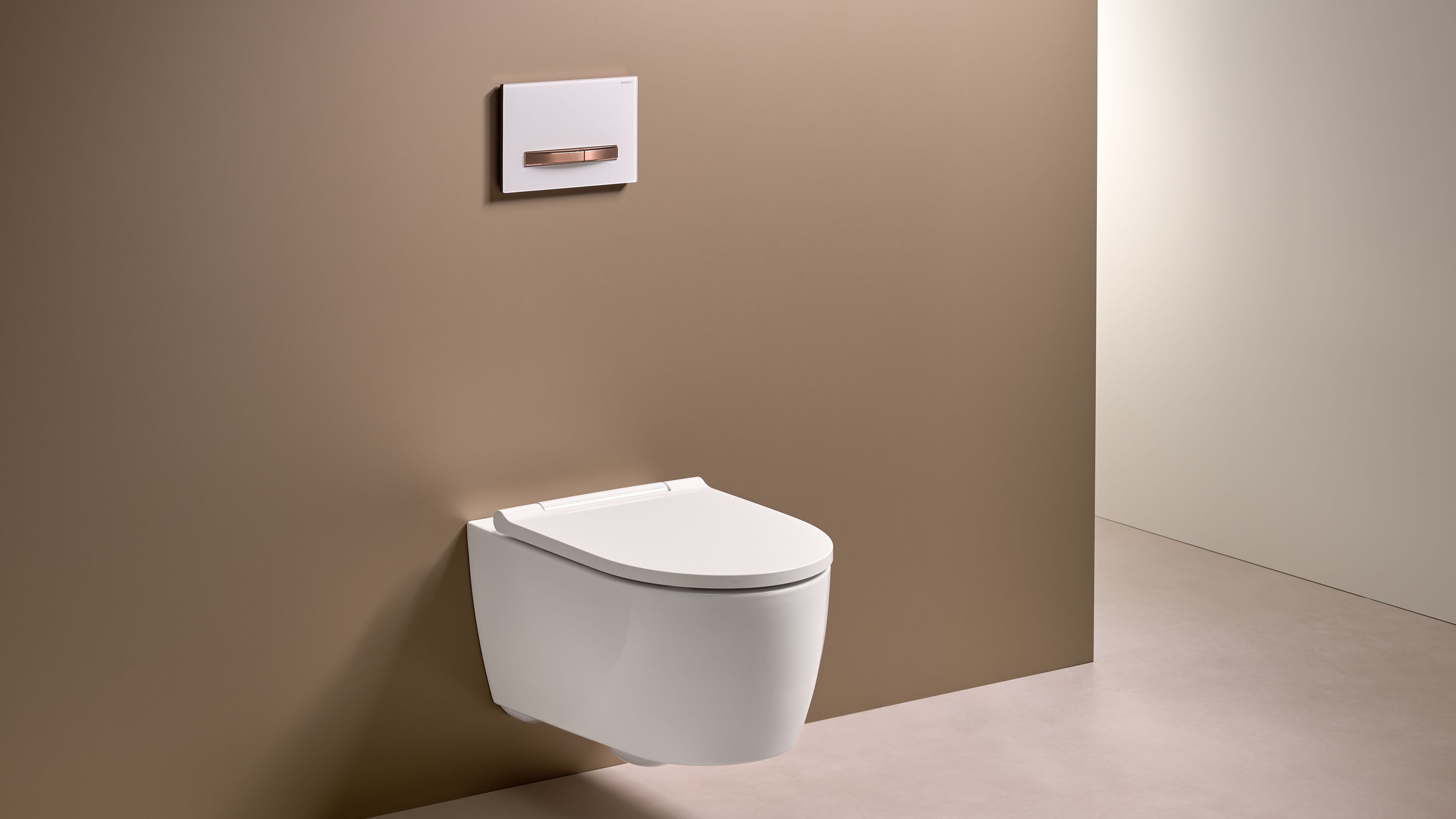 Eine moderne, wandmontierte Toilette in Weiß vor einer schlichten, braunen Wand, die einen minimalistischen Stil vermittelt.
