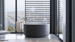Ein modernes Badezimmer mit einer runden Badewanne, großen Fenstern und einem atemberaubenden Blick auf die Landschaft.